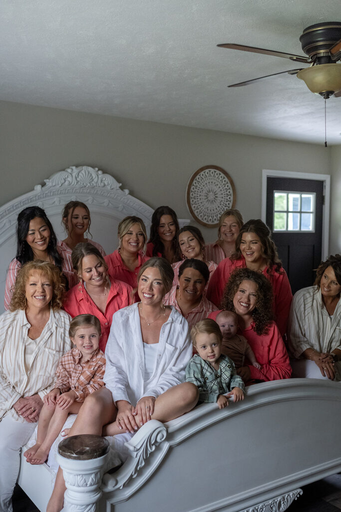 Bride and bridesmaids sitting on a bed