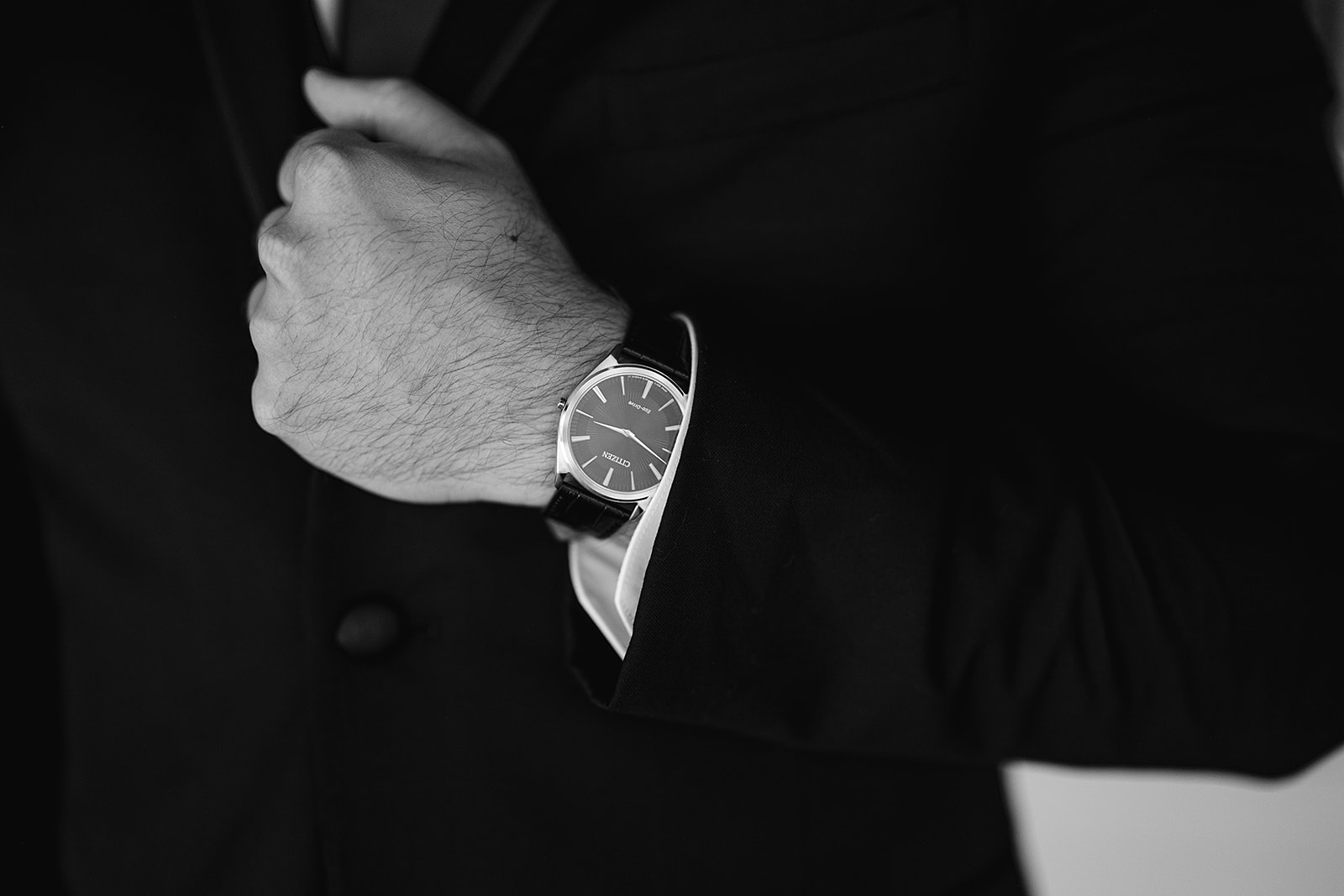 Black and white detail shot of a groom wearing his watch