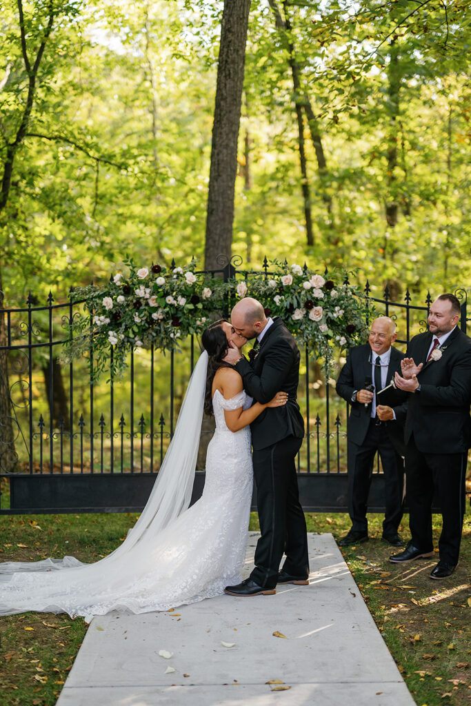 Bride and groom kissing during their outdoor fall Ritz Charles wedding ceremony in Indianapolis, Indiana