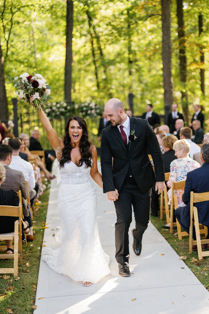 Bride and groom walking back down the aisle as husband and wife after their outdoor fall Ritz Charles wedding ceremony in Indianapolis, Indiana 