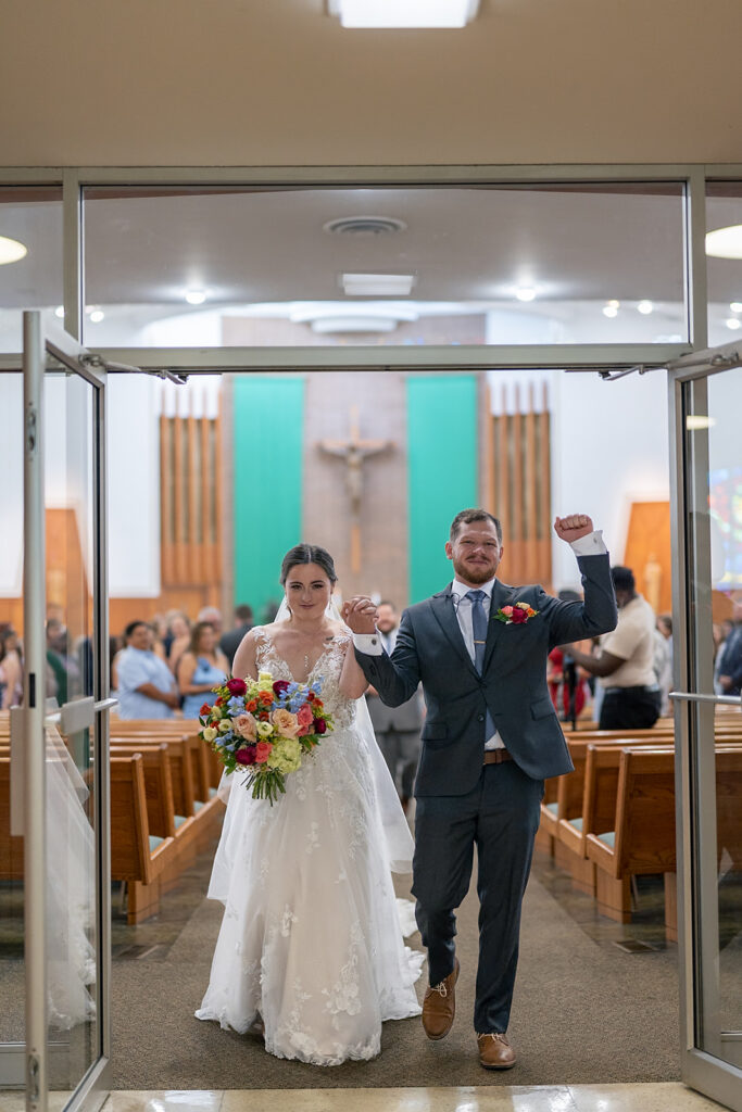 Bride and groom walking out of the  church after their ceremony