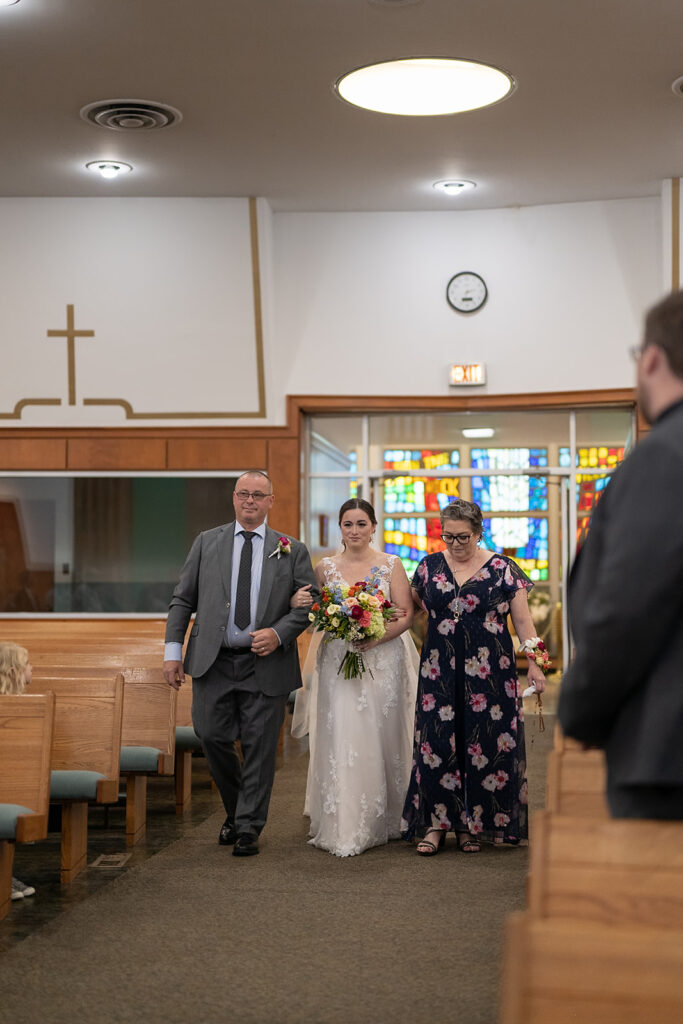 Bride walking down the aisle with her parents