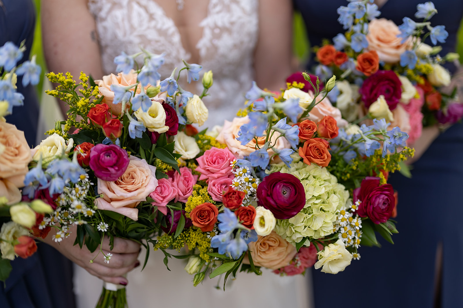 Bride and bridesmaids holding colorful summer wedding bouquets