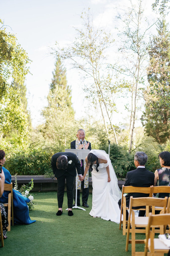 Bride and groom bowing after their wedding ceremony