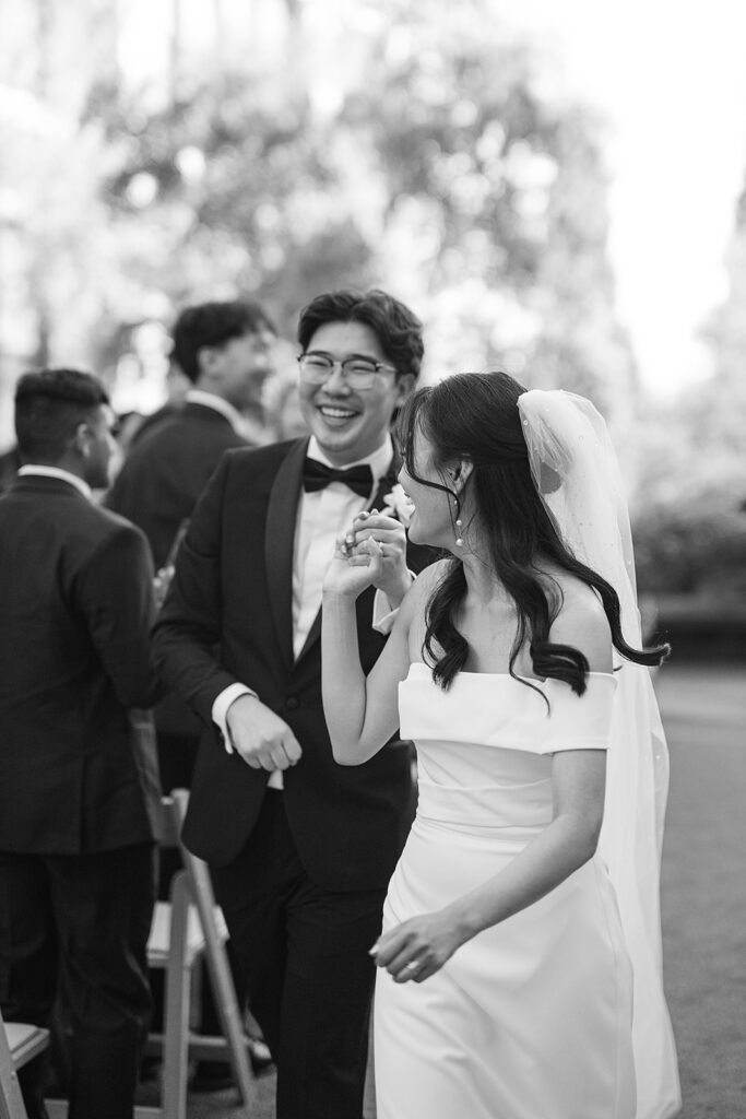 Black and white photo of a bride and groom walked down the aisle as husband and wife