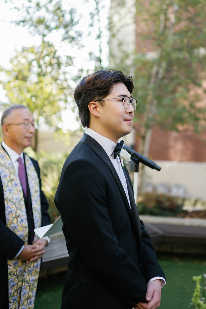 Groom watching his bride walk down the aisle