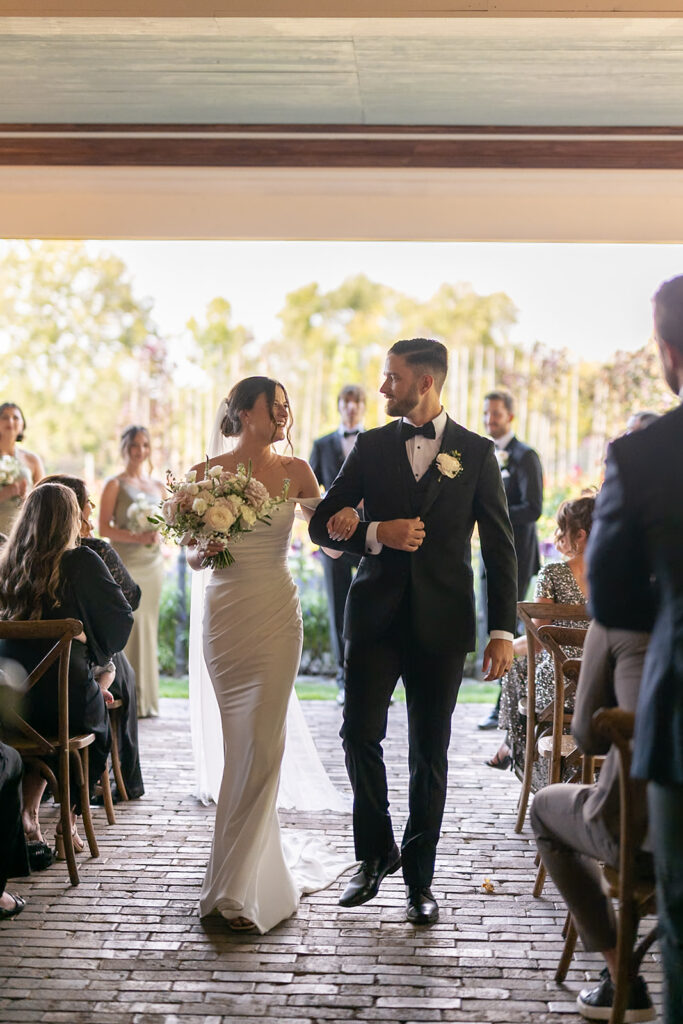 Bride and groom walking back down the aisle after their Artisan Acres Estate wedding venue on The Vernada