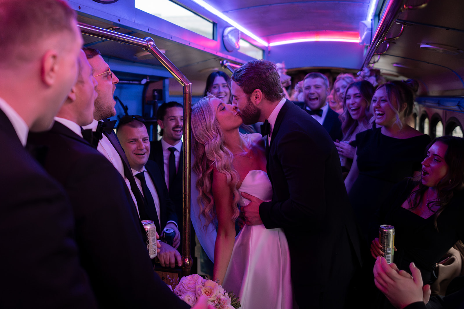 Bride and groom kissing on a party bus