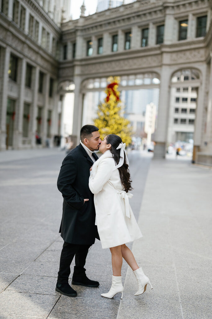 Couple kissing in front of the tree during their winter downtown Chicago engagement photos