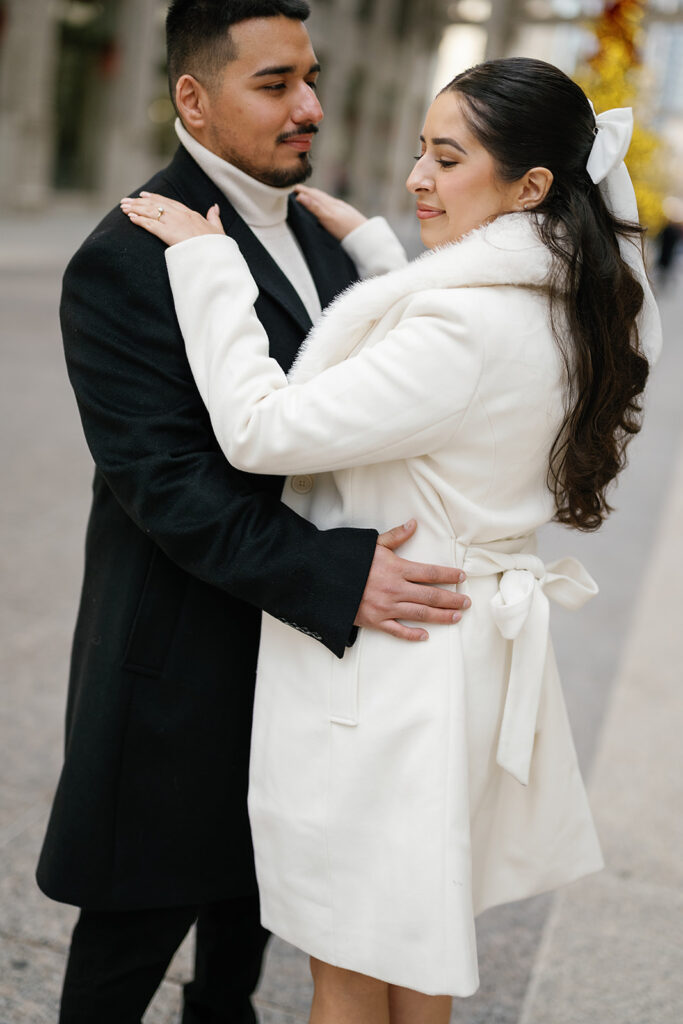 Couple posing in front of the tree during their winter downtown Chicago engagement photos