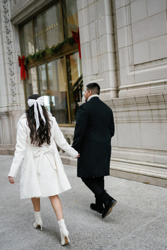 Couple holding hands as they walk downtown