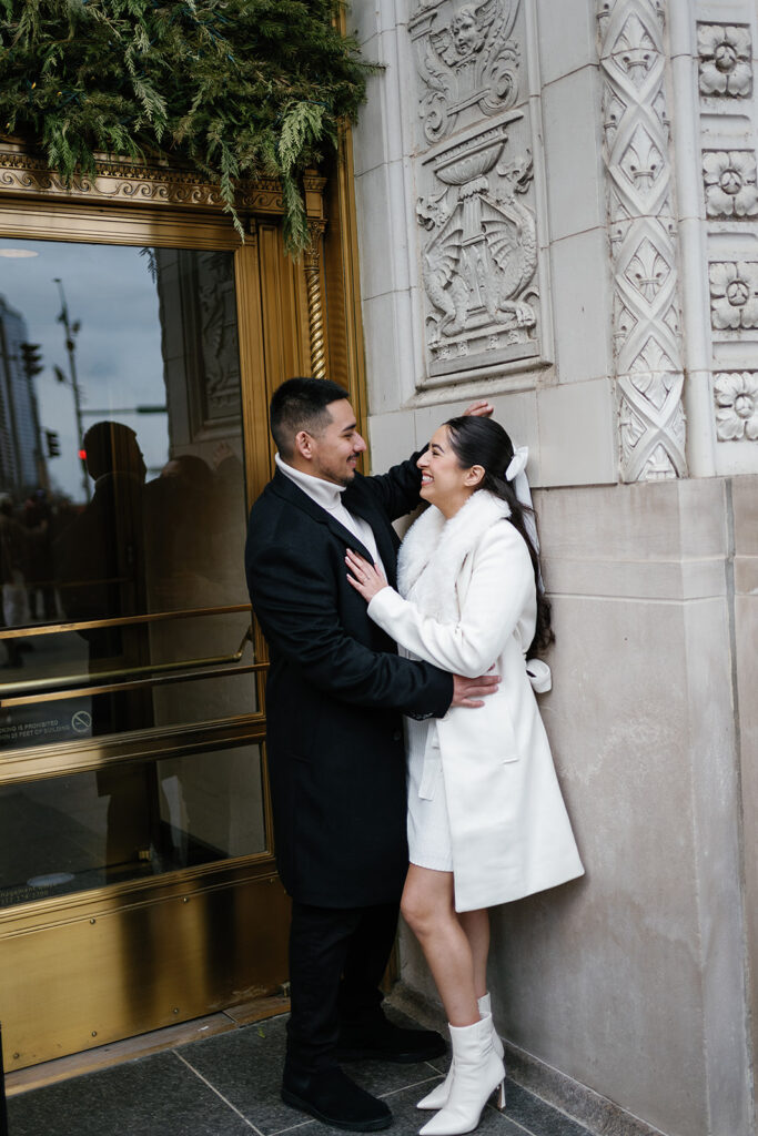 Couple posing against Wrigley Building in downtown Chicago