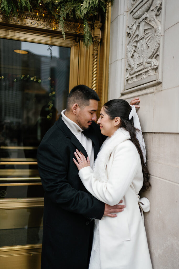 Couple posing against Wrigley Building in downtown Chicago