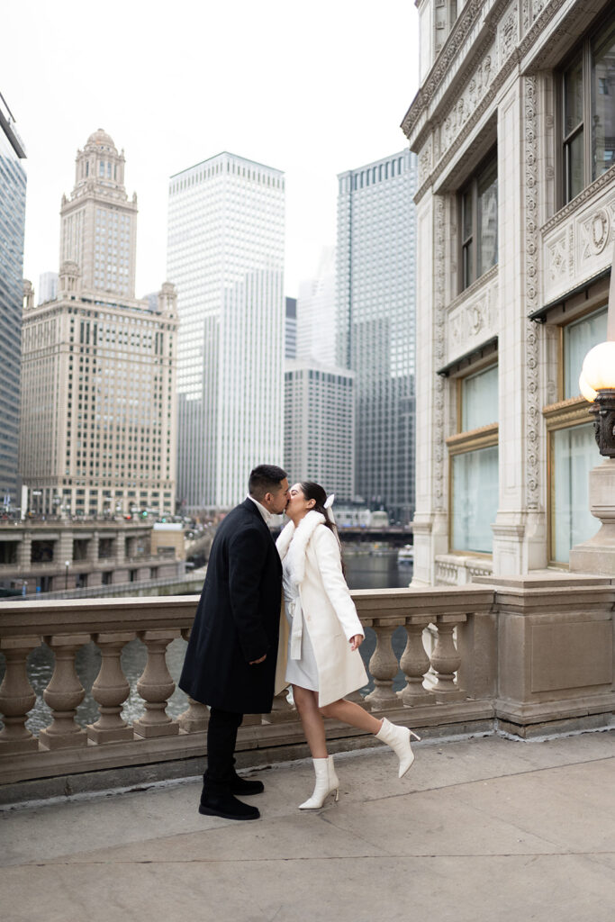 Couple kissing on the DuSable Bridge for their downtown Chicago engagement photos in the winter