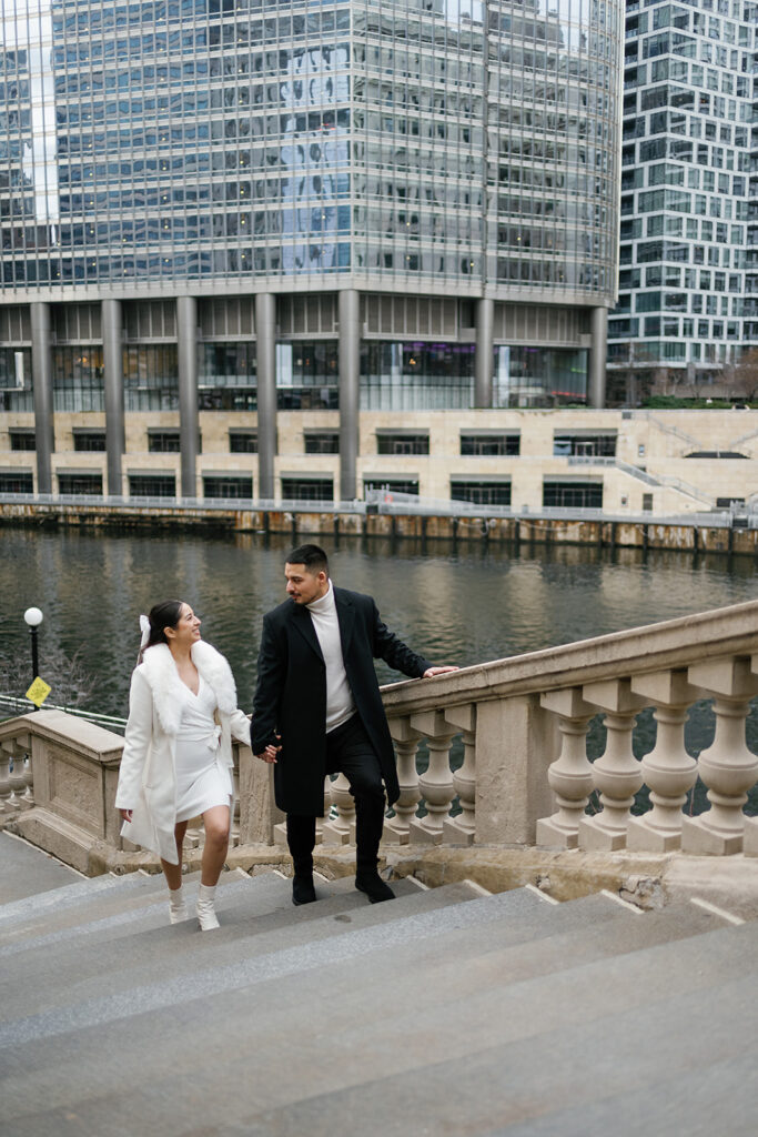 Couple walking on the steps to DuSable Bridge for their downtown Chicago engagement photos