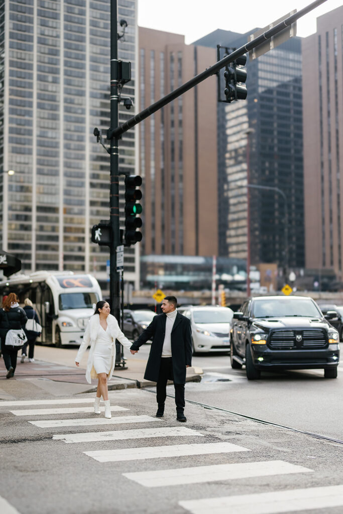 Couples walking across the street during their winter engagement photos in downtown Chicago