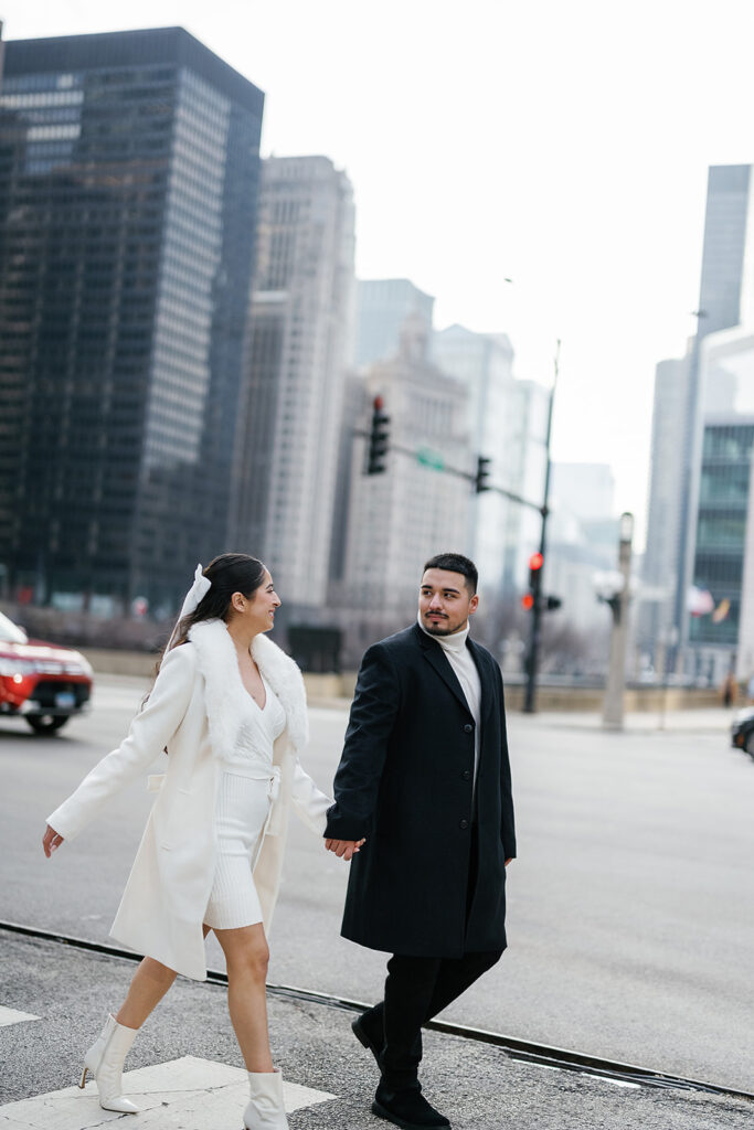 Couples walking across the street during their winter engagement photos in downtown Chicago