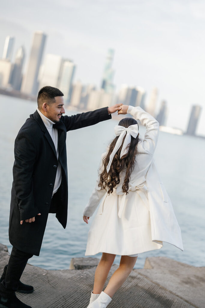 Man twirling his fiancé during their Chicago skyline engagement photos