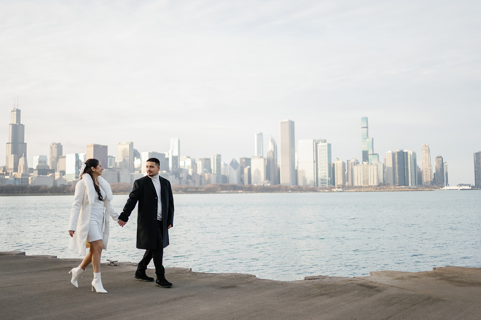 Couple walking in front of the Chicago skyline at Adler Planetarium 