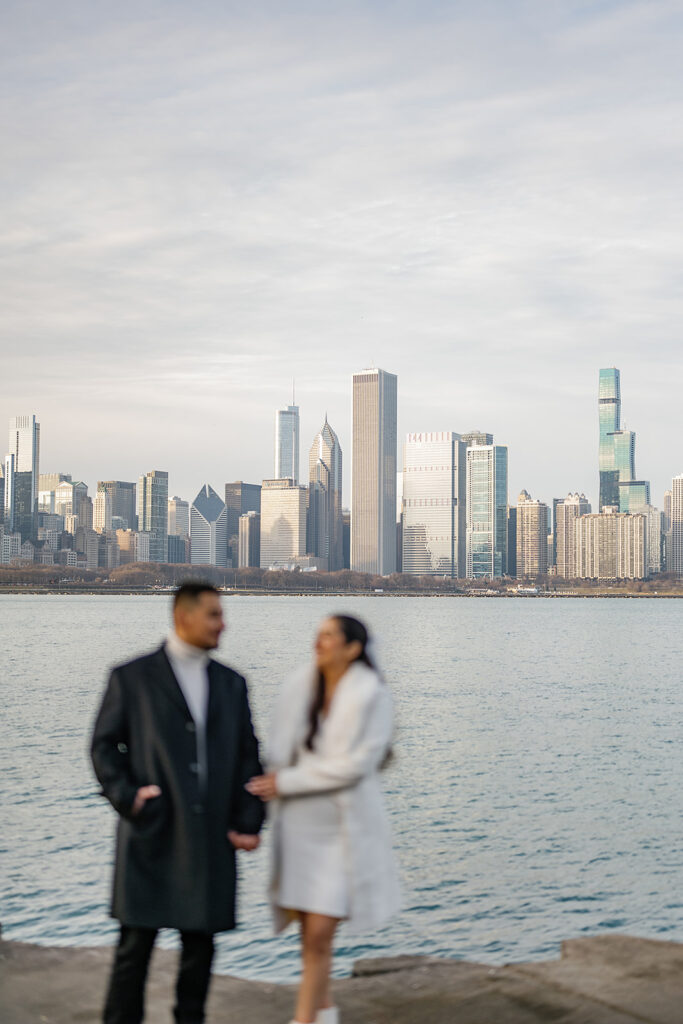 Out of focus Detroit engagement photo with the skyline behind them