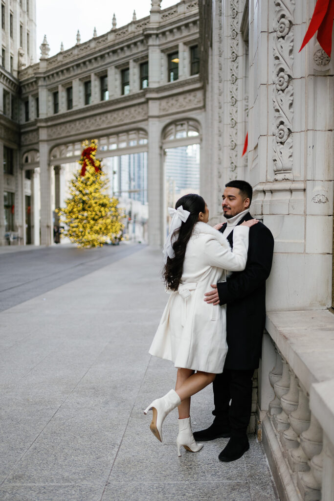 Couple posing in front of the tree during their winter downtown Chicago engagement photos