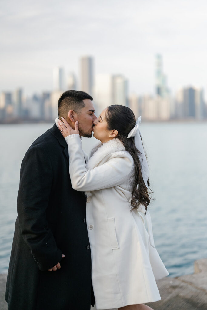 Couple kissing in front of the Chicago skyline at Adler Planetarium 