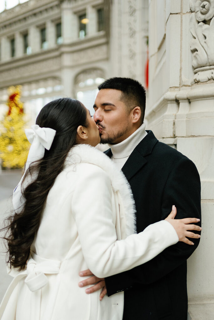 Couple kissing in front of the tree during their winter downtown Chicago engagement photos