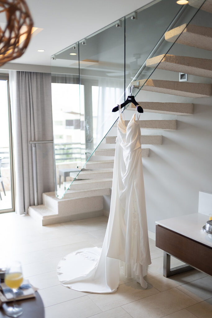 Brides wedding dress hanging from a staircase