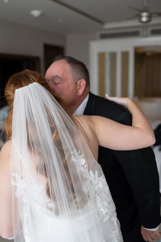 Father kissing his daughter on the cheek after sharing a first look