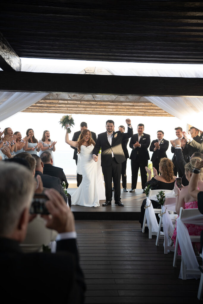 Bride and groom walking back down the aisle as husband and wife during their Sky Wedding ceremony at Hideaway at Royalton Riviera Cancun