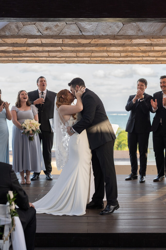 Bride and groom kissing during their during their Sky Wedding ceremony at Hideaway at Royalton Riviera Cancun