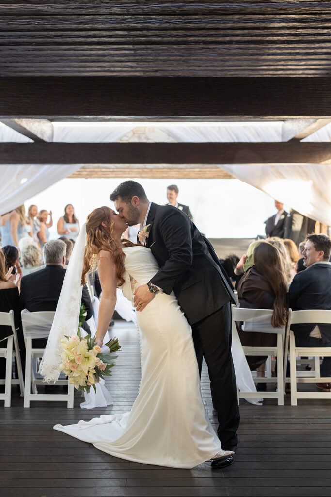 Bride and groom end of aisle kiss during their Sky Wedding ceremony at Hideaway at Royalton Riviera Cancun