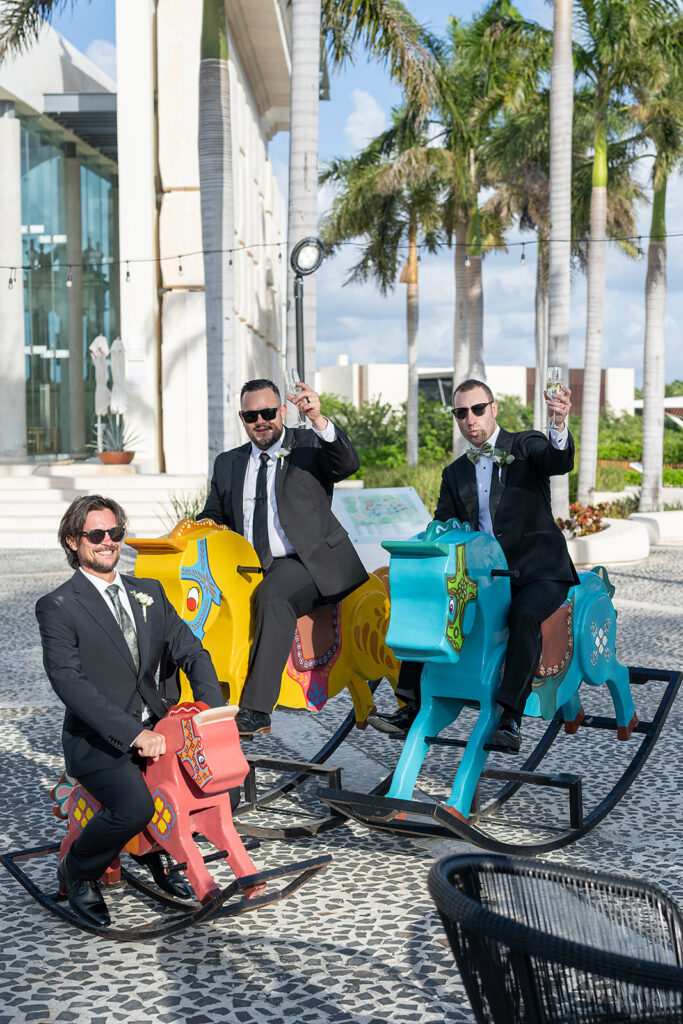 Groom riding colorful rocking horses with his groomsmen