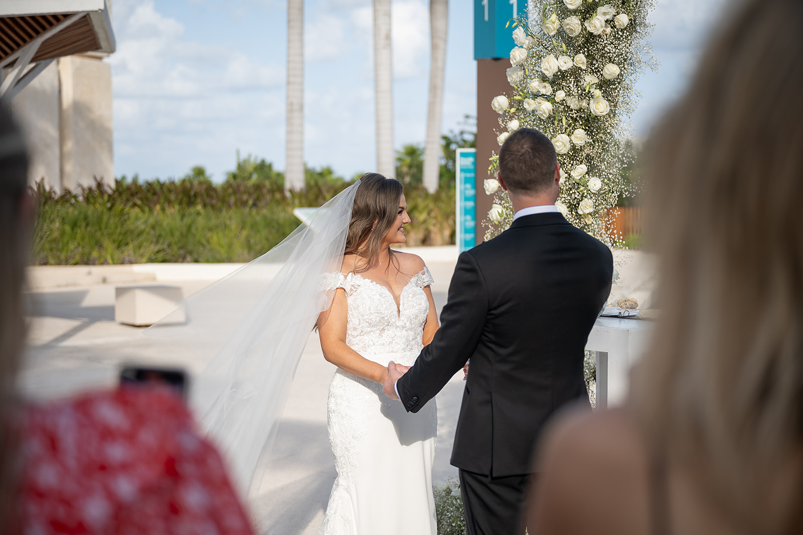 Bride and groom holding hands at the altar for their outdoor Grand Palladium Costa Mujeres wedding ceremony at Deck in The Village