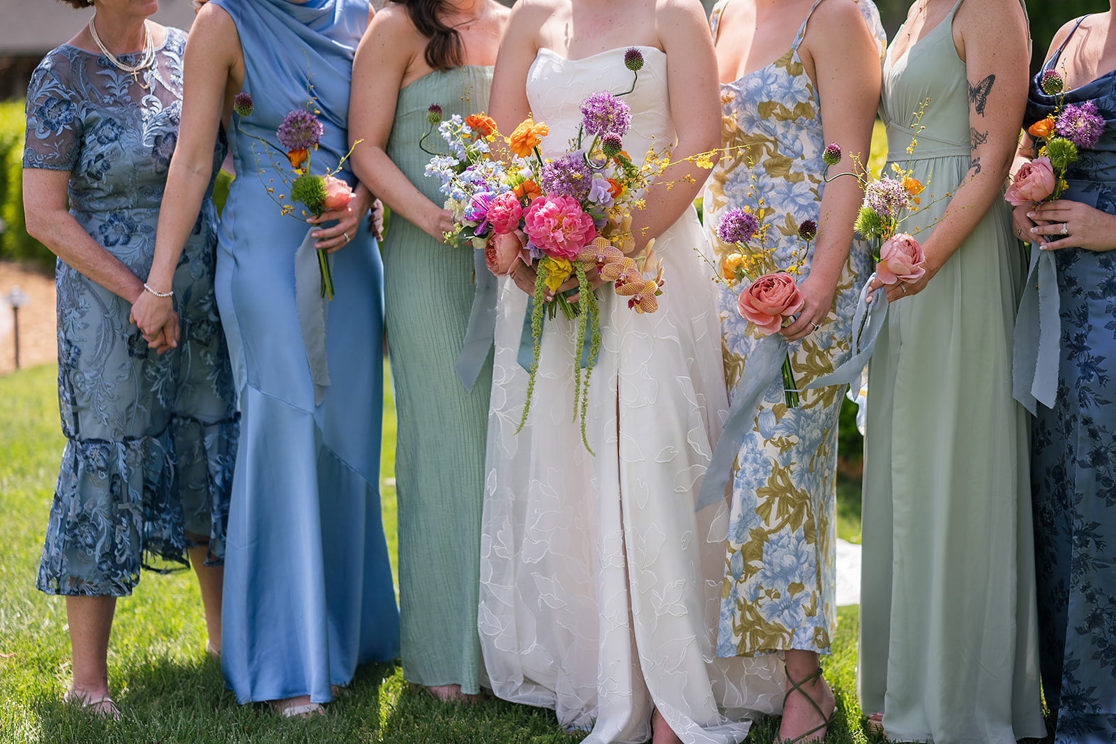 Bride and bridesmaids holding colorful wedding bouquets from a colorful Asheville wedding