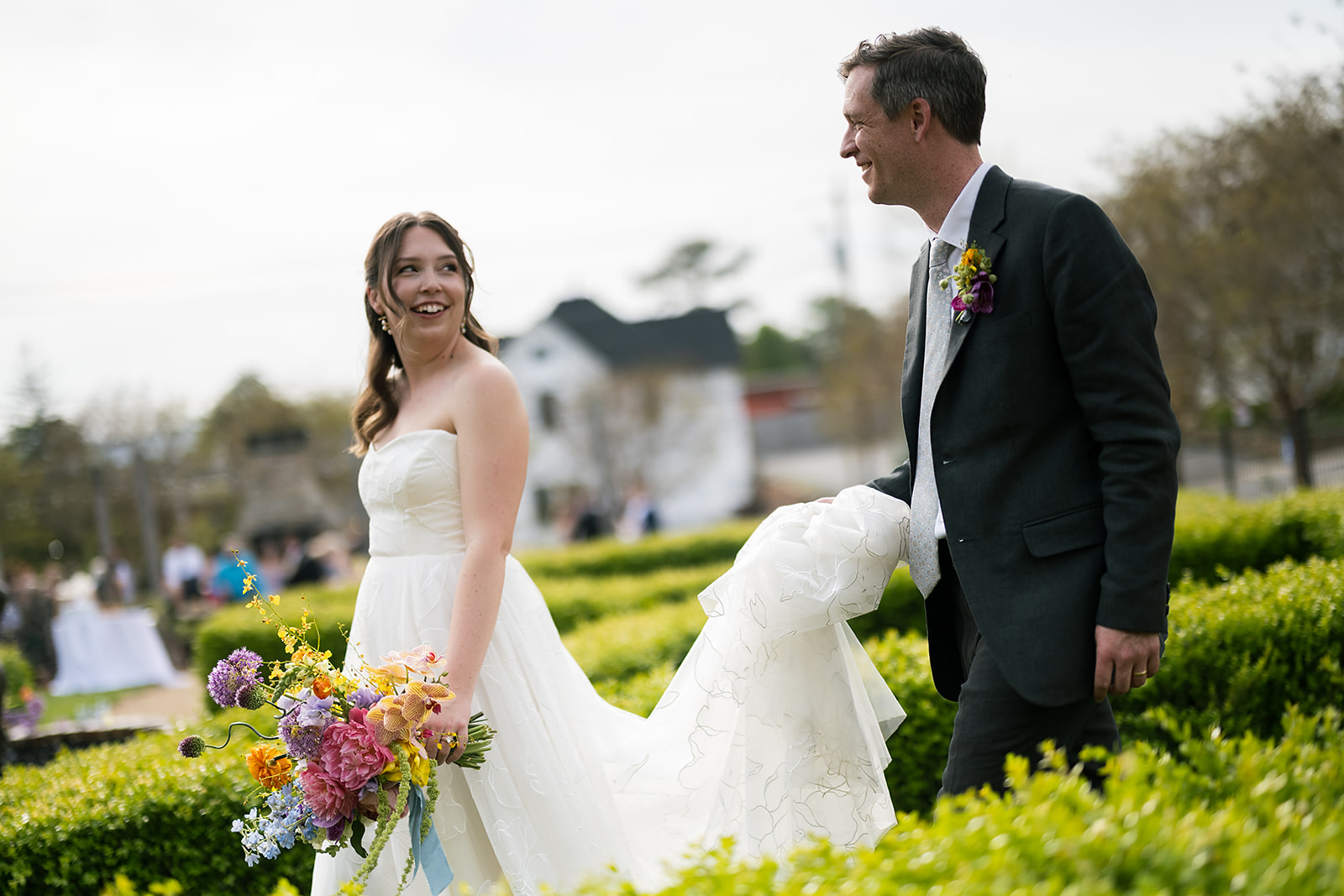 Playful moment as couple walks side by side in garden