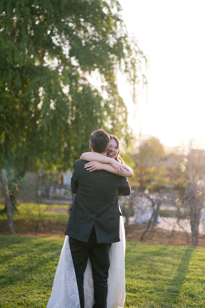 Groom lifting his bride in the air and hugging her