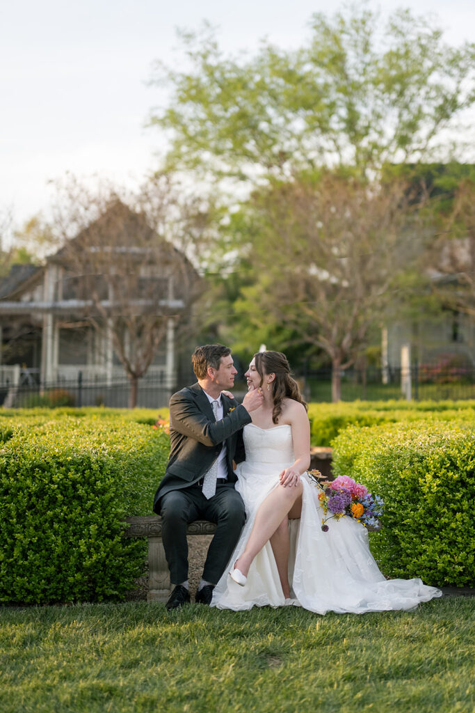 Bride and grooms romantic wedding photos while sitting on a bench at The Bunn House in Asheville, NC