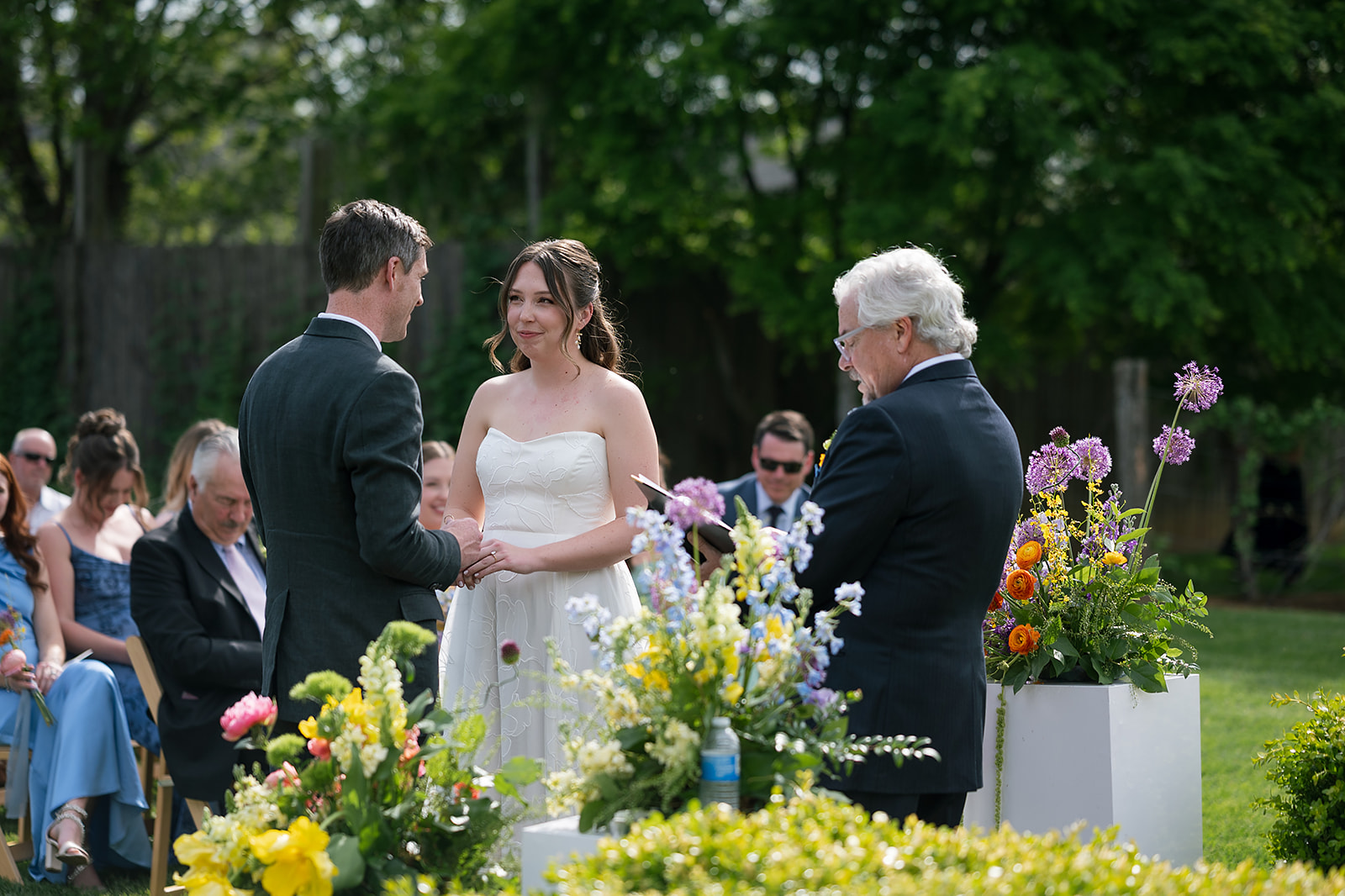 Emotional moment during wedding ceremony with couple smiling at each other under spring sunlight