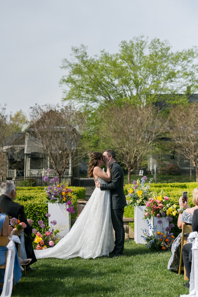 Bride and groom kissing during their outdoor wedding ceremony