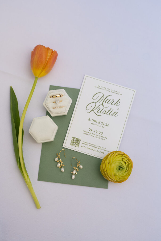 Flat lay of bride’s accessories with floral details and wedding invitation at The Bunn House