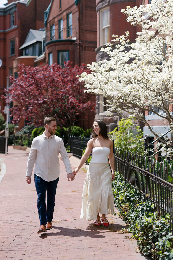 Couple holding hands and walking down the sidewalks in Washington DC
