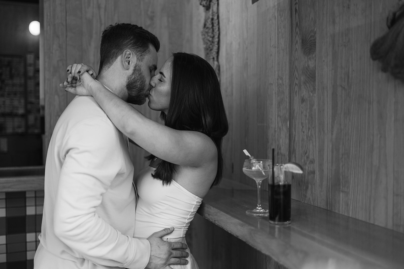 Black and white photo of a couple kissing at Jane Jane