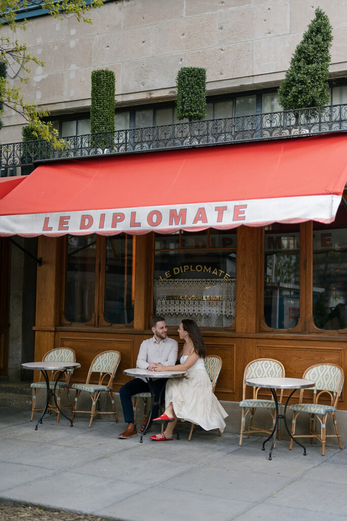Couple sitting in front of Le Diplomate for their engagement photos in Washington DC
