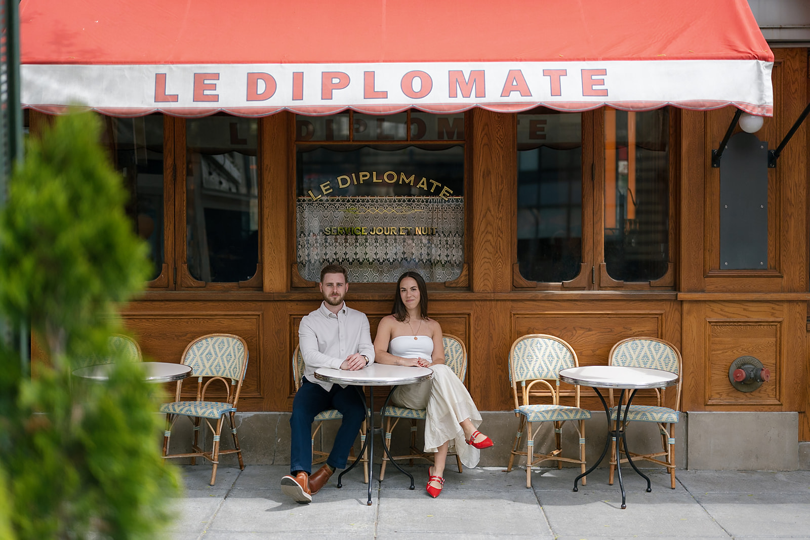 Couple posing outside of Le Diplomate for their engagement photos in Washington DC