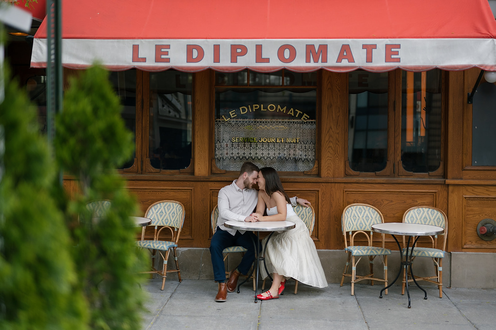 Couple posing outside of Le Diplomate for their engagement photos in Washington DC