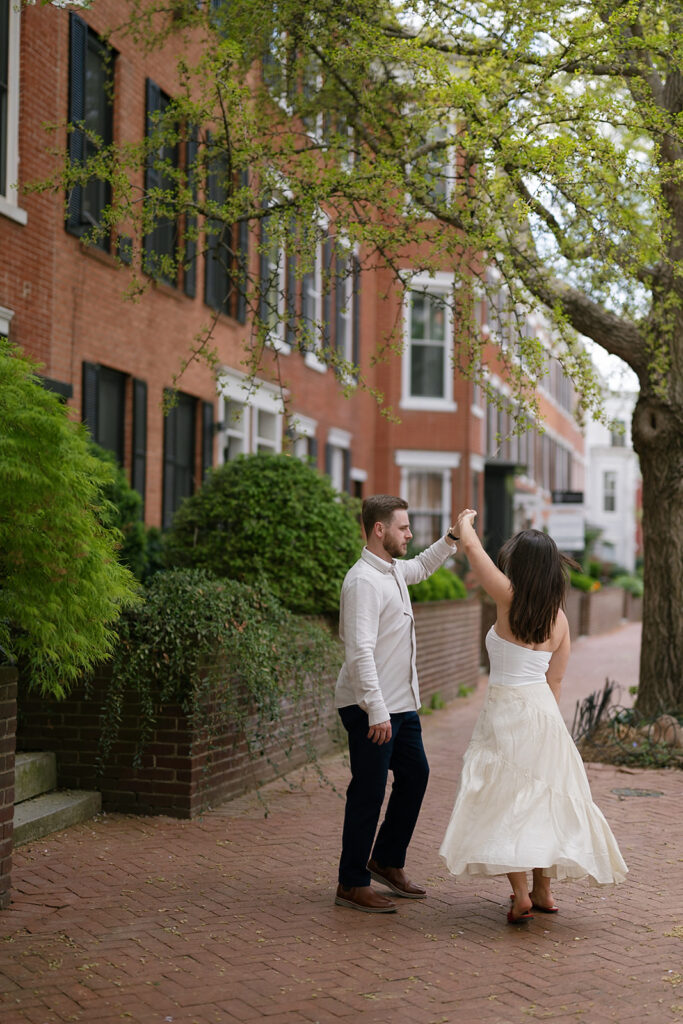 Man twirling his fiancé on the sidewalks of Washington DC