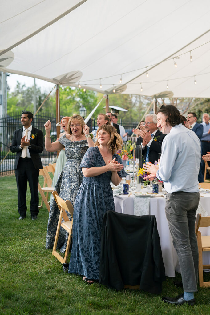 Guests clapping as the bride and groom enter their reception