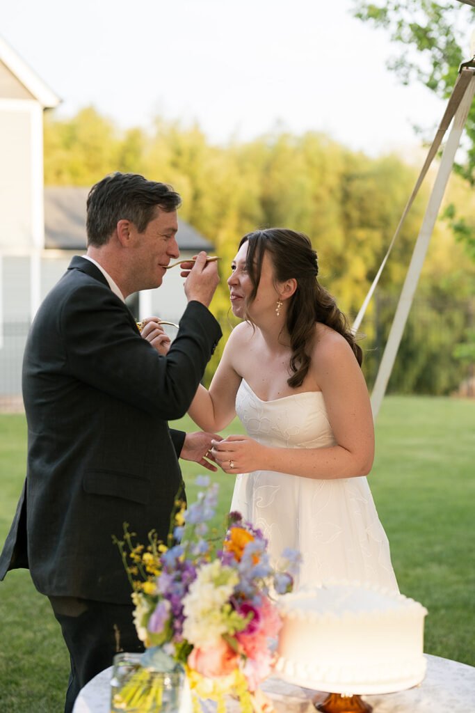 Bride and groom feeding each other cake