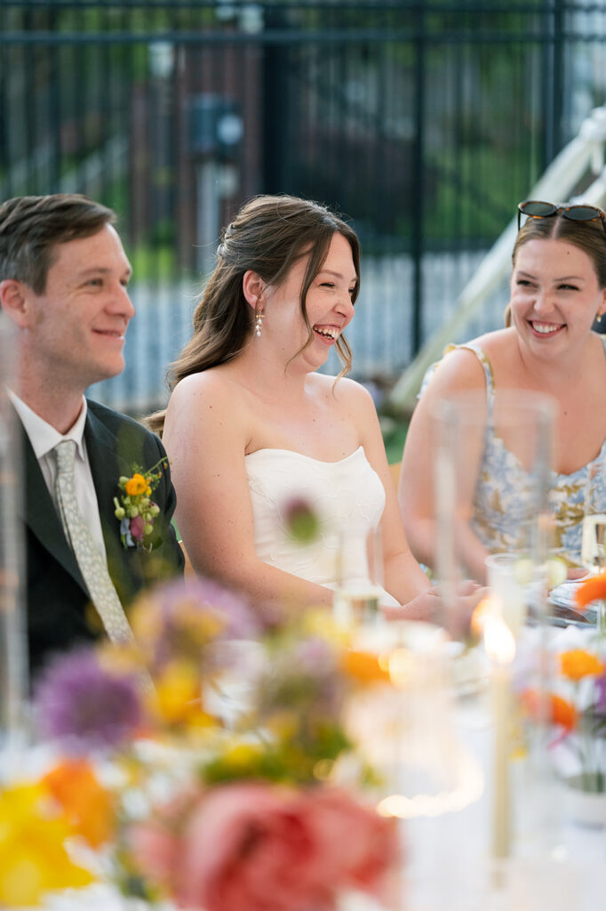 Bride and groom laughing during speeches